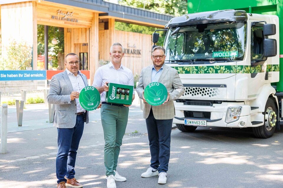 Harald Raidl, Supply Chain Director der Brau Union, Gastronom Paul Kolarik und Dominic Schmid, Obmann der Sparte Tourismus und Freizeit in der Wirtschaftskammer Wien, mit einem elektrischen Lkw der Brau Union vor der Luftburg - Kolarik im Prater