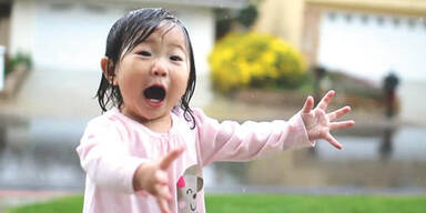 M&auml;dchen freut sich &uuml;ber ersten Regen