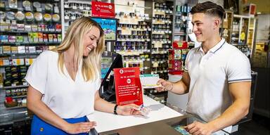 18plus - junge Frau, junger Mann - in Trafik bei Kauf von Lotterien-Produkten