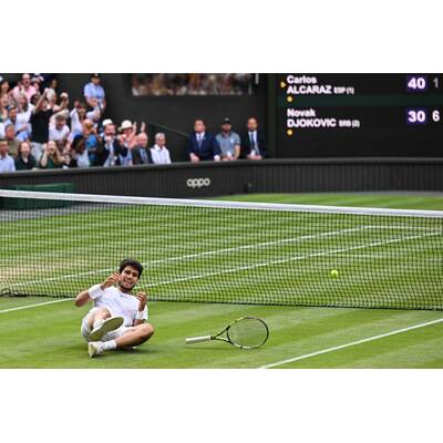 Tag 14: Carlos Alcaraz präsentiert stolz die Trophäe.