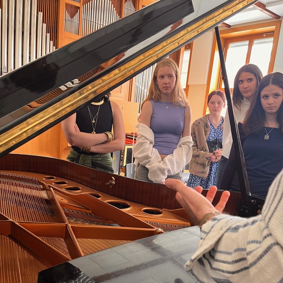 Die Teilnehmerinnen hören der Musikerin aufmerksam zu. 
