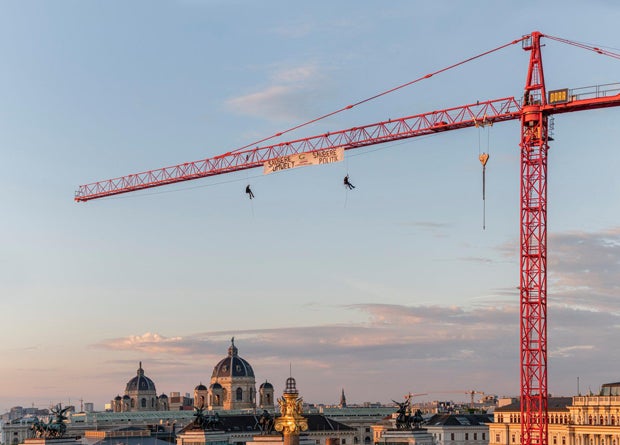 Die Grünen Wien entrollen Banner auf Baukran über Parlament