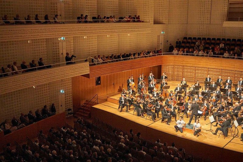 Klima-Aktivisten kleben sich während Konzert an Podium