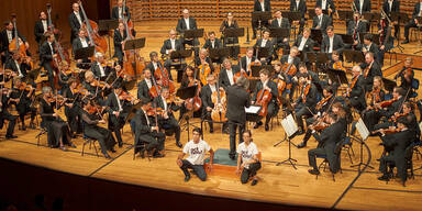 Klima-Aktivisten kleben sich während Konzert an Podium