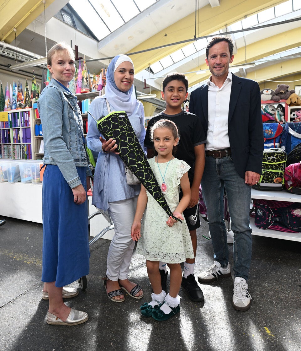 Martina Polleres-Hyll (Leiterin der Caritas-Bildungsangebote) und der Wiener Caritasdirektor Klaus Schwertner sowie eine Familie.