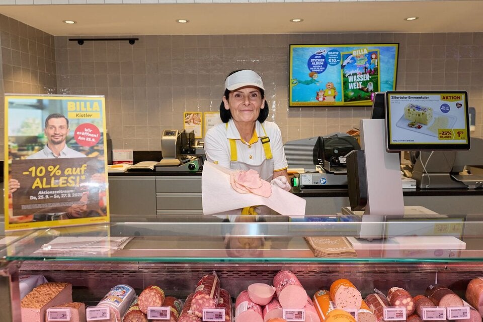 Mitarbeiter in der Feinkostabteilung beraten Kunden.