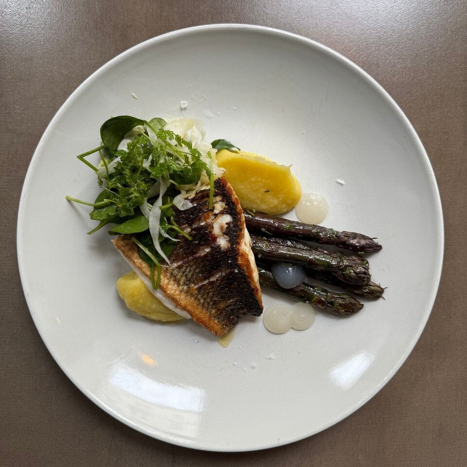 Branzinofilet mit gegrilltem Grünspargel, Yuzu-Gel und Erdäpfel-Zitronencreme. 