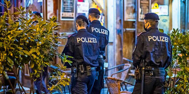 3 Polizisten vor einem Lokal kontrollieren die Corona Regeln