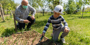 Opa mit Kind bei der Gartenarbeit