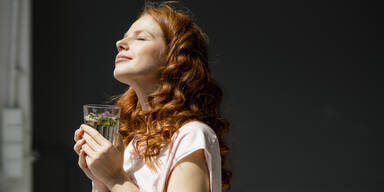 Frau mit Wasserglas am Fenster