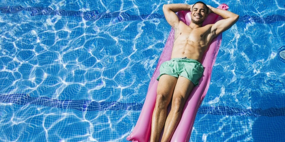 Mann auf Luftmatratze im Wasser