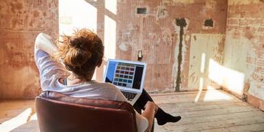 Frau plant ihren Raum vor Computer