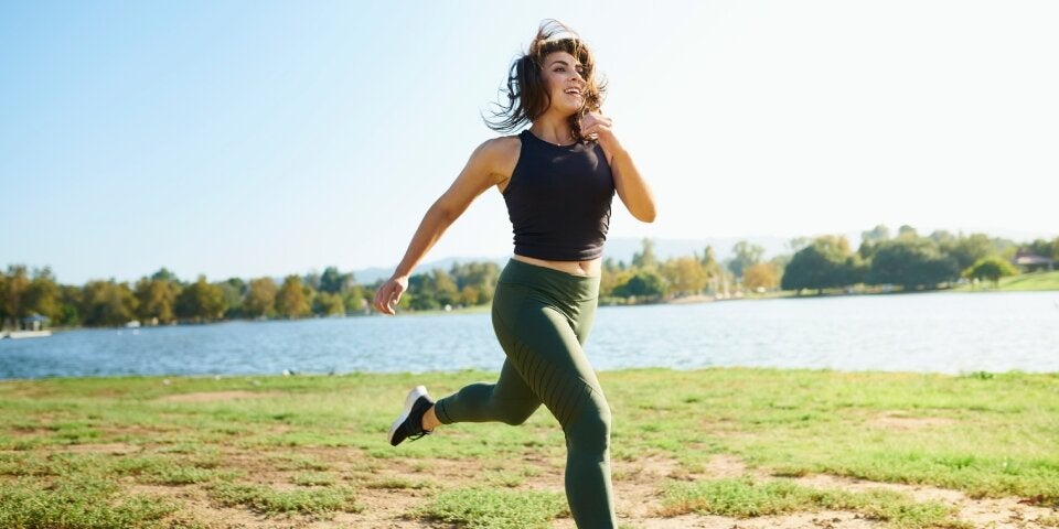 Frau joggt über eine Wiese