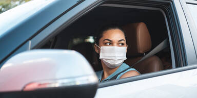 Frau m Auto mit Maske