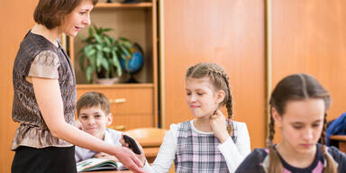 Lehrerin nimmt Schülerin das Handy ab