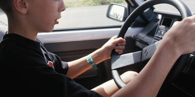 Kind am Steuer Auto Bursch Junge Teenager Jugendlicher