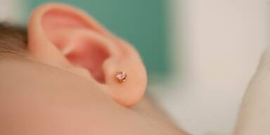 Mutter l&auml;sst 1-Tag altem Baby Ohrl&ouml;cher stechen