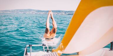 Mann rutscht Tretbootrutsche in den See