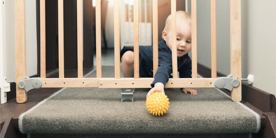 Baby vor einem Treppengitter