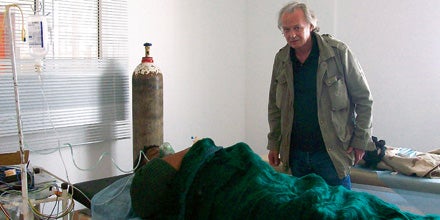 Karl Wendl an einem Krankenbett im provisorischen Spital.
