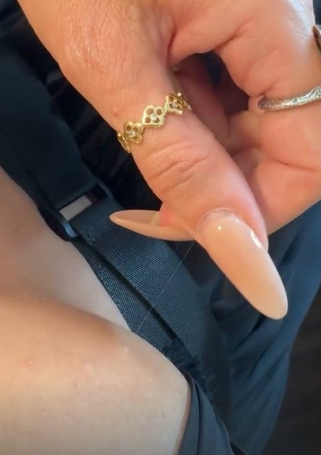 Heidi zeigt auf Instagram ein langes weißes Haar, das ihr aus dem Busen wächst. 