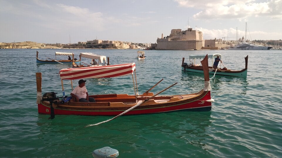 Mediterranes Treiben. Zwischen den historischen Mauern von St. Angelo pendeln bunte Taxiboote über den Grand Harbour.