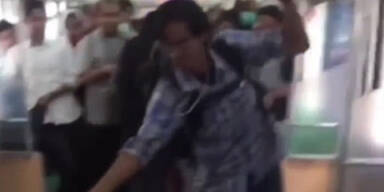 Mann t&ouml;tet Schlange in vollem Zug mit den H&auml;nden