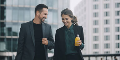 L&auml;chelnder Mann und Frau im Business Outfit am reden