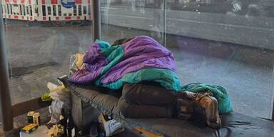 Obdachloser schläft auf Bank
