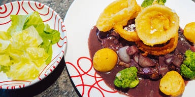 Zwiebelrostbraten mit Zwiebelringen und frittierten Erdäpfeln