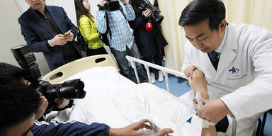 Arzt züchtet Ohr auf Unterarm des Patienten