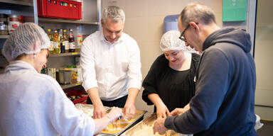 Kanzler paniert Schnitzel für Obdachlose in der "Gruft"