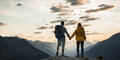 Paar steht auf einem Berg und genießt die Landschaft