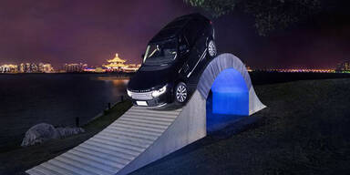 Luxus-SUV fährt über Brücke aus Papier