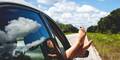 Roadtrip - Frauenfüße hängen aus dem Autofenster