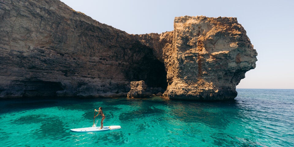 Stand-up-Paddling vor pittoresken Felsformationen. 