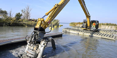 Bagger saugen Schlamm aus H&auml;fen am Neusiedler See