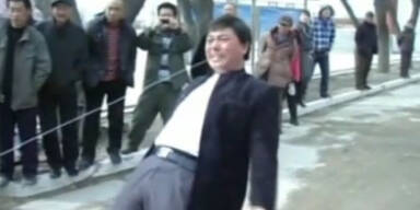 Chinese zieht zwei PKW mit den Z&auml;hnen