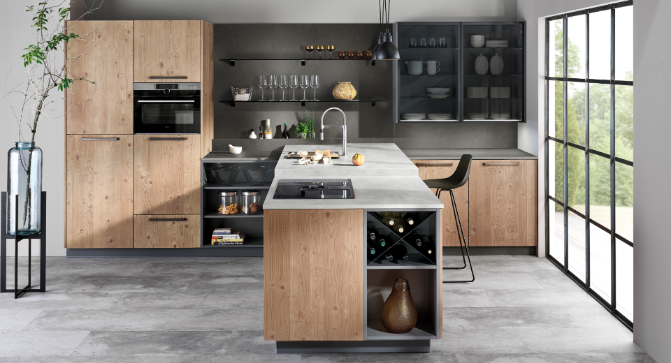 Die Kombination aus Kücheninsel und Hochschrankzeile bietet viel Stauraum und eine großzügige Arbeitsfläche. 