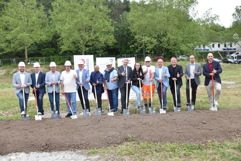 Feierlicher Spatenstich in der Triester Bundesstraße 12: KommR Andreas Holzmann (Obmann, MÖGEN, 7.v.l.), LAbg. Hermann Hauer (8.v.l.), Bgm. Walter Jeitler (4.v.r.), Bgm. LAbg. Mag. Christian Samwald (3.v.r.), Ing. Robert Kallinger (Bereichsleiter, STRABAG, 2.v.l.), Florian Kazanits (Kaufmännischer Bereichsleiter, STRABAG, l.), DI (FH) Mario Hameseder (technischer Bereichsleiter, STRABAG AG, 5.v.l.), Andreas Fischer (Polier, STRABAG, 5.v.r.), KommR Bmstr. Josef Panis (3.v.l.) und Arch. DI Wolfgang Lederbauer (Bauleiter, MÖGEN, 4.v.l.) gemeinsam mit Ing. Carina Faustmann, M.A. (Bauamt Wimpassing, 6.v.r.) sowie Vertreter des Gemeinderats.