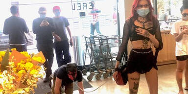 Hier geht eine Domina mit Mann an der Leine einkaufen