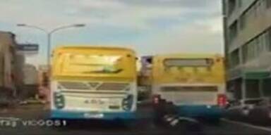 Unverletzt! Verrückter Biker rutscht unter Bus