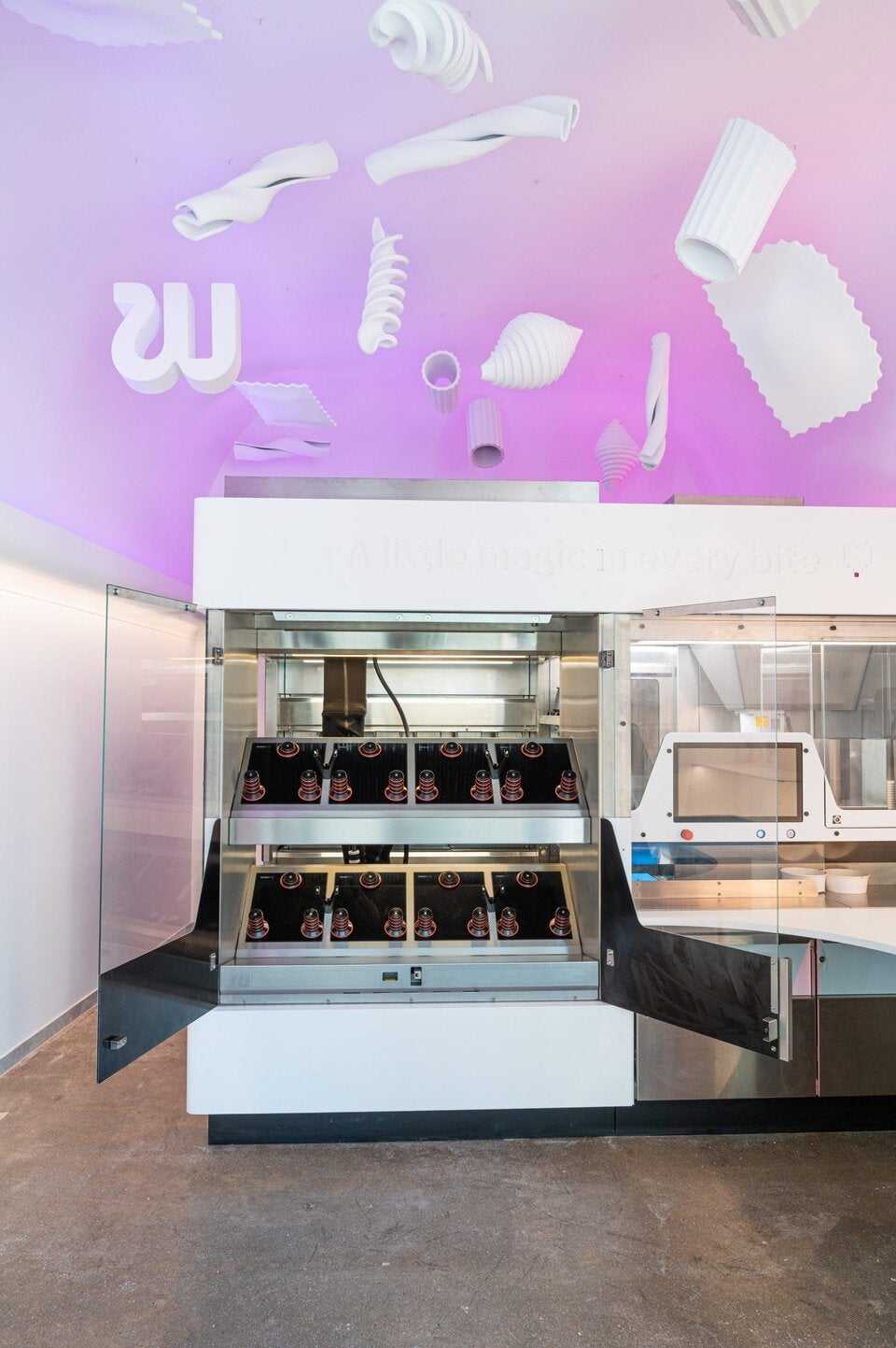 Der Kochroboter der Burger brutzelt und Pasta kocht.