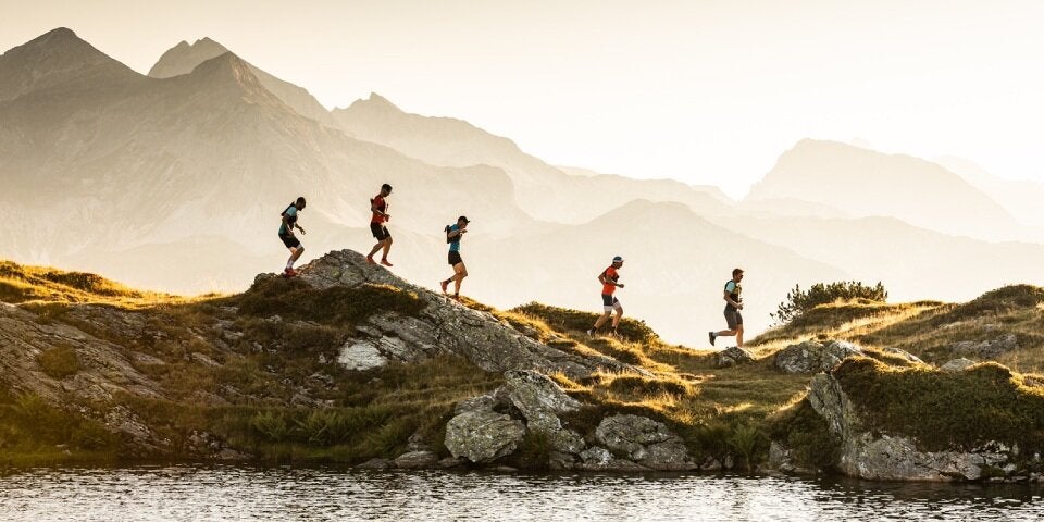 Personen joggen einen Berg entlang