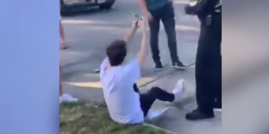 Mann sitzt auf Boden