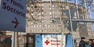 Berlusconi mit verbundenem Gesicht heim