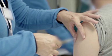 Mann wird in den Oberarm geimpft