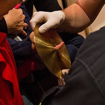 Bub steckte mit Finger in Schlagzeug fest