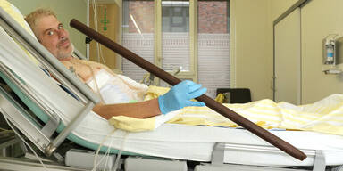 Mann von Zaunstange gepf&auml;hlt