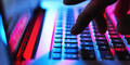 Hand auf beleuchteter PC-Tastatur